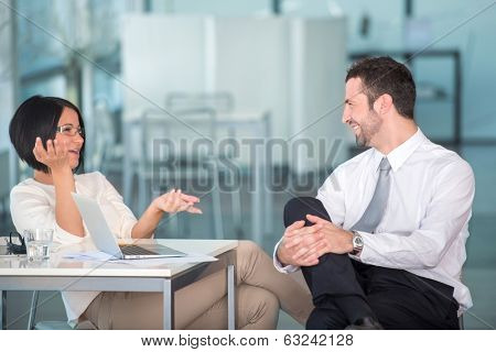 Two colleagues talking relaxed in office