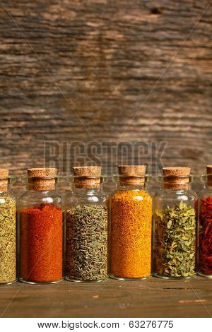 Spices, herbs and seeds for cooking in little jar in a row
