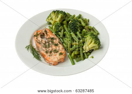 Roast Fish With Green Vegetables On A White Plate Isolated