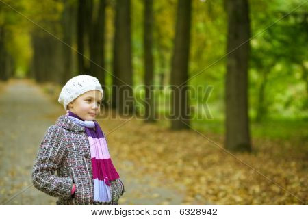 mladá pěkná blondýnka stojí v krásném parku snění