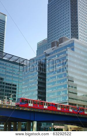 ONDON, CANARY WHARF UK - APRIL 13, 2014 - DLR bridge with train Modern glass architecture