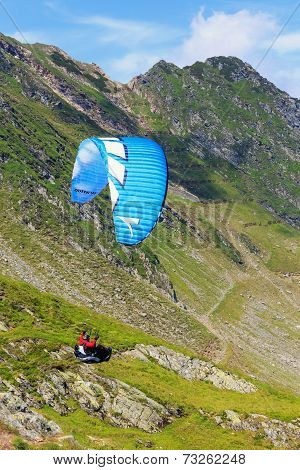 Unidentified paraglider in Balea Lake Fagaras Mountain Romania.