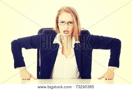 Attractive business woman by the table, bossy behaviour. Isolated on white.