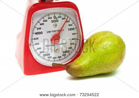 Ripe Pear And Kitchen Scales Close Up On A White Background