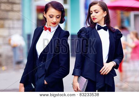 Two Gorgeous Women Posing In Black Suits