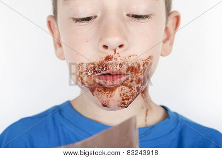 A boy eat chocolate in front of a white background
