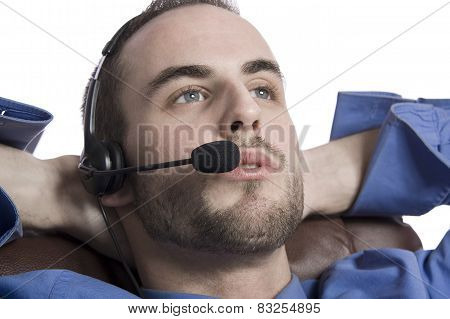 Concentrated young businessman using laptop and phone at office