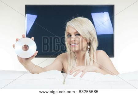 Woman in the living room show a CD-DVD