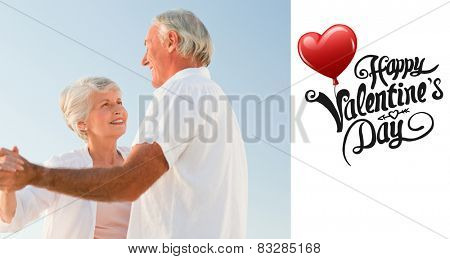 Senior couple dancing on the beach against cute valentines message