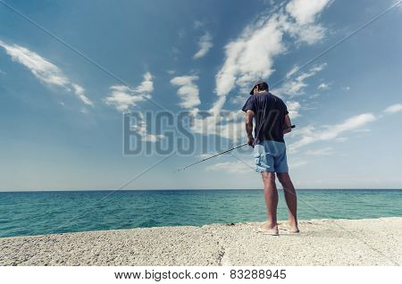Fisherman fishing near the sea