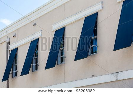 Blue Storm Shutters On Stucco Building
