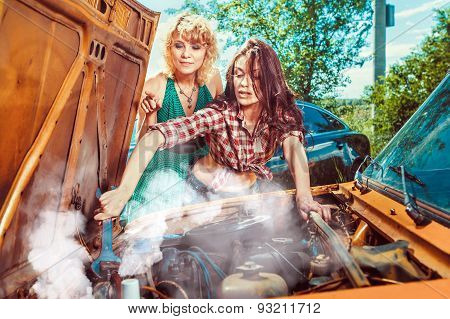 Beautiful Woman Mecanic Is Repairing A Car Another Woman Is Watching.
