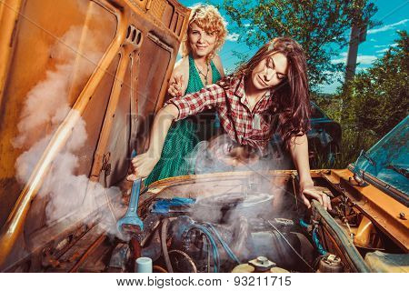 Beautiful Woman Mecanic Is Repairing A Car Another Woman Is Watching.