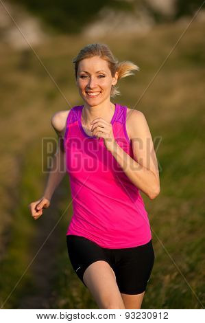 Beautiful Young Woman Runns Cross Country On A Mountian Path At Sunrise