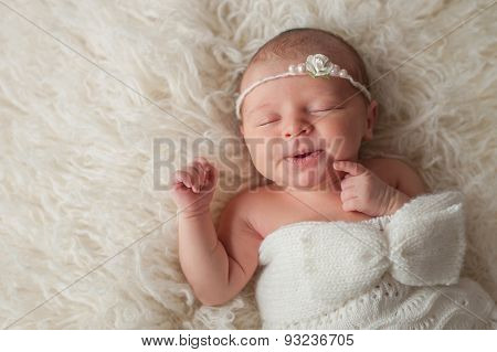 Newborn Baby Girl Wearing A White Knitted Bonnet
