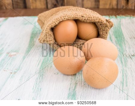 Egg In Burlap Sack On Wooden Background