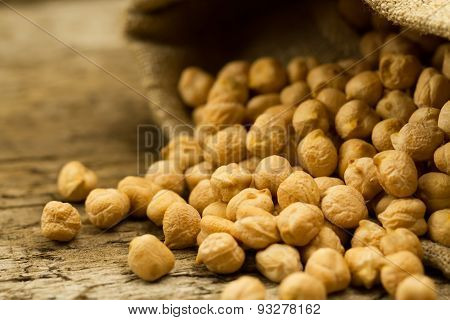 Scattered Chickpeas From A Jute Bag On Old Wooden Background