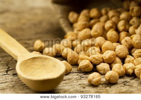 Scattered Chickpeas From A Jute Bag With A Spoon On Old Wooden Background
