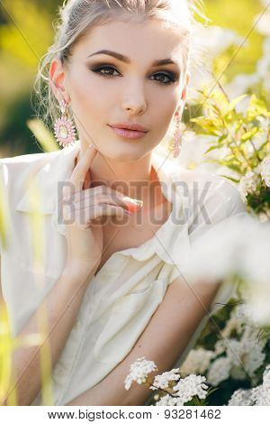 Beautiful happy woman in a flowery spring garden.