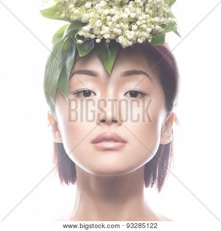 Fashion beautiful girl oriental type with delicate natural make-up and flowers. Beauty face.