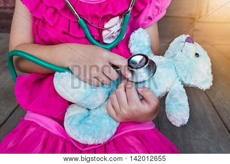 Child Playing Doctor Or Nurse With Plush Toy Bear At Home.