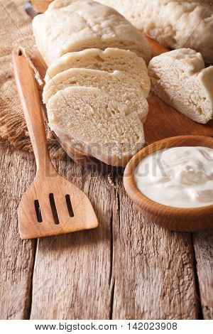 Czech Cuisine: Sliced Boiled Knedliks Close-up On Chopping Board. Vertical