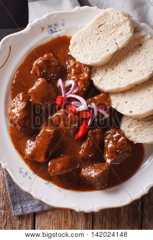 Thick Goulash With Dumplings On A Plate Close-up. Vertical Top View
