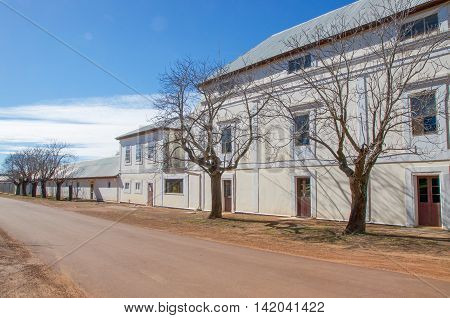 NEW NORCIA,WA,AUSTRALIA-JULY 15,2016: The Benedictine Monastery cream and white exterior with leafless trees in the historic monastic town of New Norcia, Western Australia.