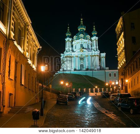 Andriyivskyy Descent with the Saint Andrew's Church (Kiev) night view. All buildings are illuminated.