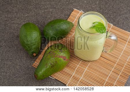 Avocado green smoothie and mint on bambo mat