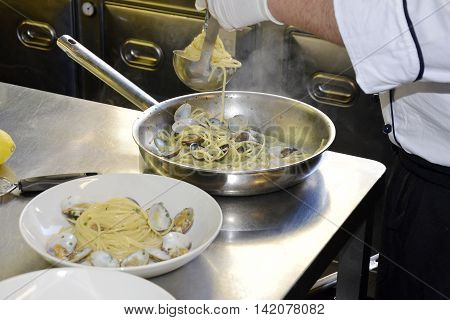 Preparetion dish of spaghetti with clams in a restaurant kitchen