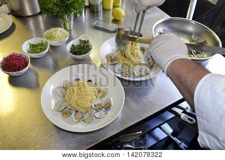 Preparetion dish of spaghetti with clams in a restaurant kitchen