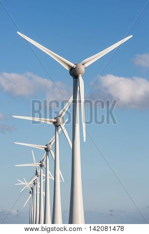 Row of large wind turbines and blue sky