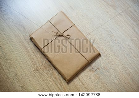 wrapped gift kraft paper on a wooden background.