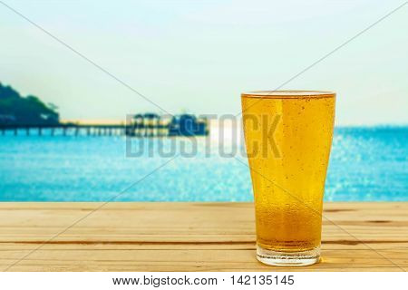 Beer glass on a blurred background of the sea.