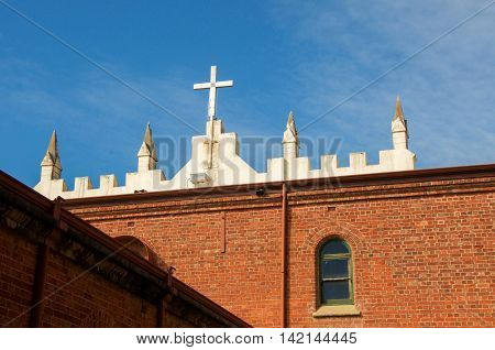 NEW NORCIA,WA,AUSTRALIA-JULY 15,2016: Cross detail over the the brick Spanish gothic St. Ildephonsus College for Boys in New Norcia, Western Australia.
