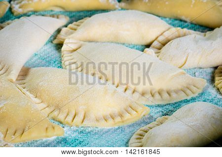 Homemade Agnolotti filled with ricotta on green cloth
