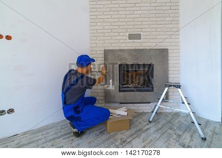 Fireplace installing in white brick wall