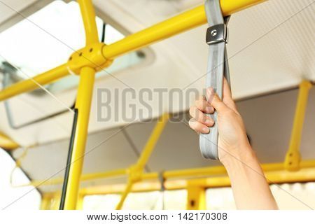 Hand holding handle on the public transport