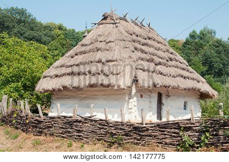 National Museum of Folk Architecture and Life Pirogovo. Traditional wattle and daub hut with thatched roof