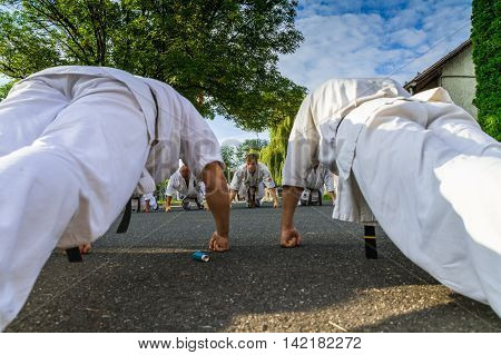 Miskolc Hungary - August 2. 2016: Athletes are pressed on the asphalt ground during the international summer training camp for Kyokushin Karate.