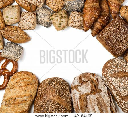 Top view of frame of bakery product assortment with bread loaves buns rolls croissants and pretzels isolated on white background space for text.