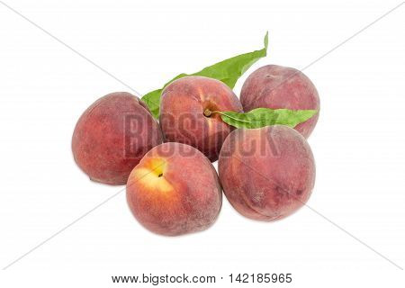 Several ripe fresh peaches with leaves on a light background
