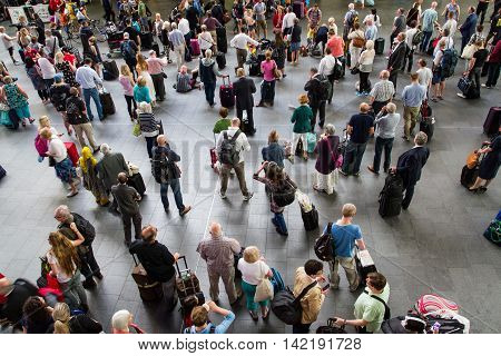 KING'S CROSS STATION, LONDON, UK - JULY 21, 2016. Looking down from above onto the crowded concourse of King's Cross Station in London during the peak time rush as rail passengers and commuters wait for information about their trains.