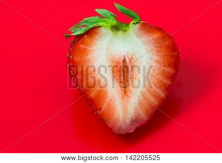 Cleaved single strawberry isolated on red background and clipping path