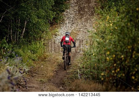 athlete mountainbiker rides a bicycle on a mountain trail. extreme sports