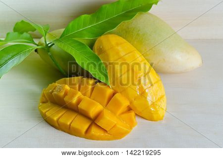 Mango Ripe With Nicely Cut Pieces And Leaf On Wooden Board