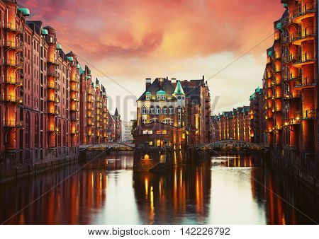 Old Speicherstadt in Hamburg illuminated at night. Sunset background