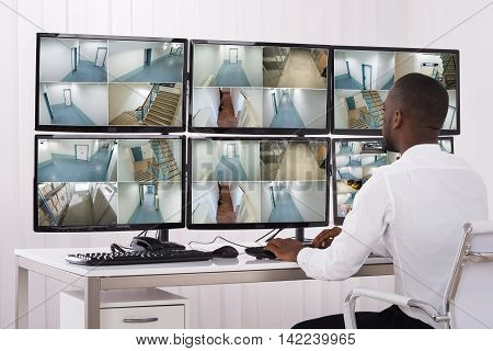 Young Male Operator Looking At Multiple Camera Footage On Computer