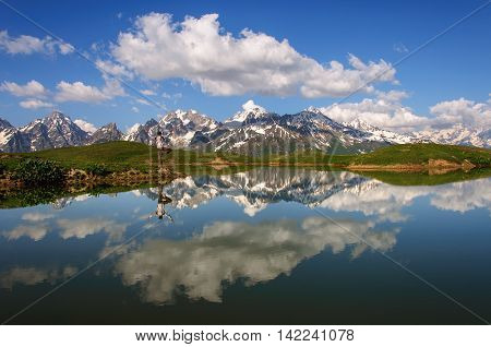 A man practices yoga on the shore of Lake koruldi. Georgia, Svaneti